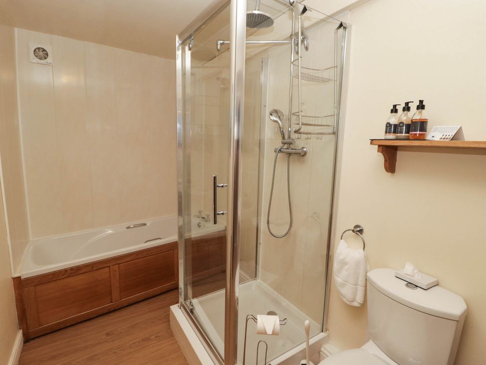 A bathroom with a shower, bathtub, toilet, and sink at Ty Mawr Country House in Carmarthen