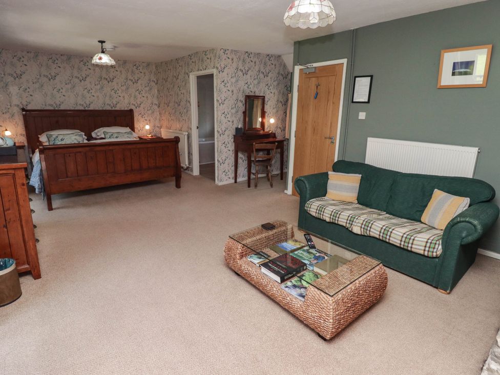 A bedroom with two beds and a seating area at Ty Mawr Country House in Carmarthen