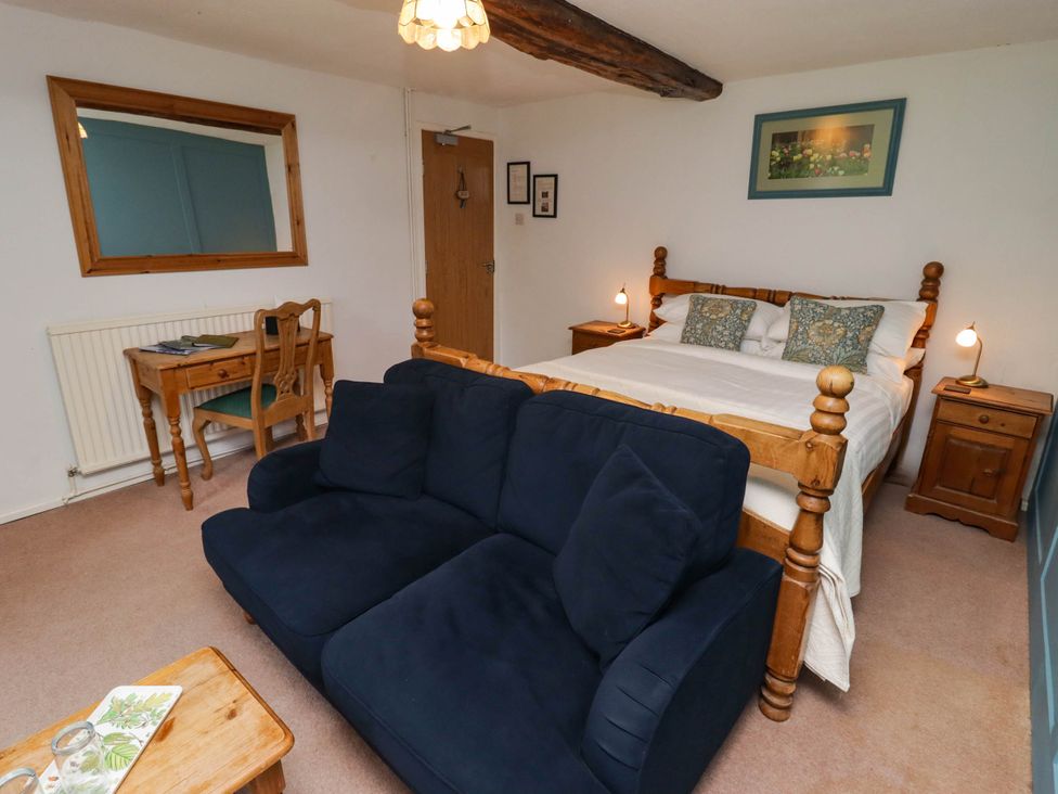 A bedroom with a bed, desk, and seating area at Ty Mawr Country House in Carmarthen