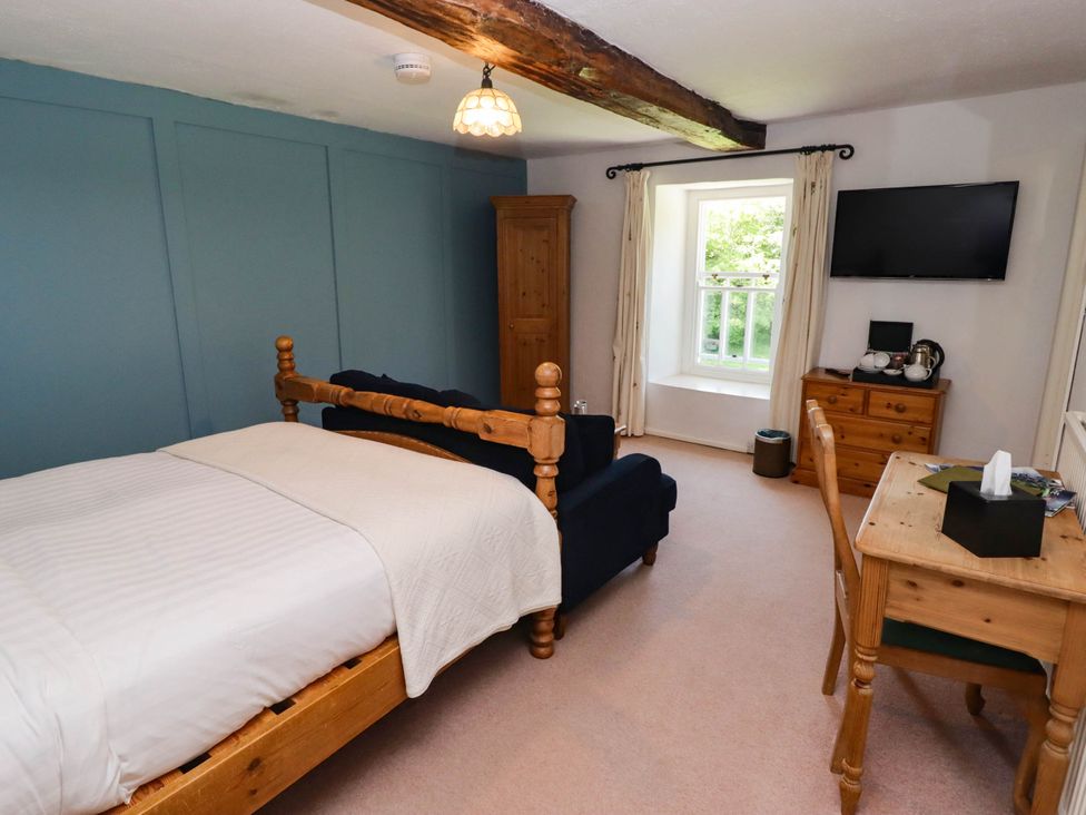 A bedroom with a bed and seating area at Ty Mawr Country House in Carmarthen