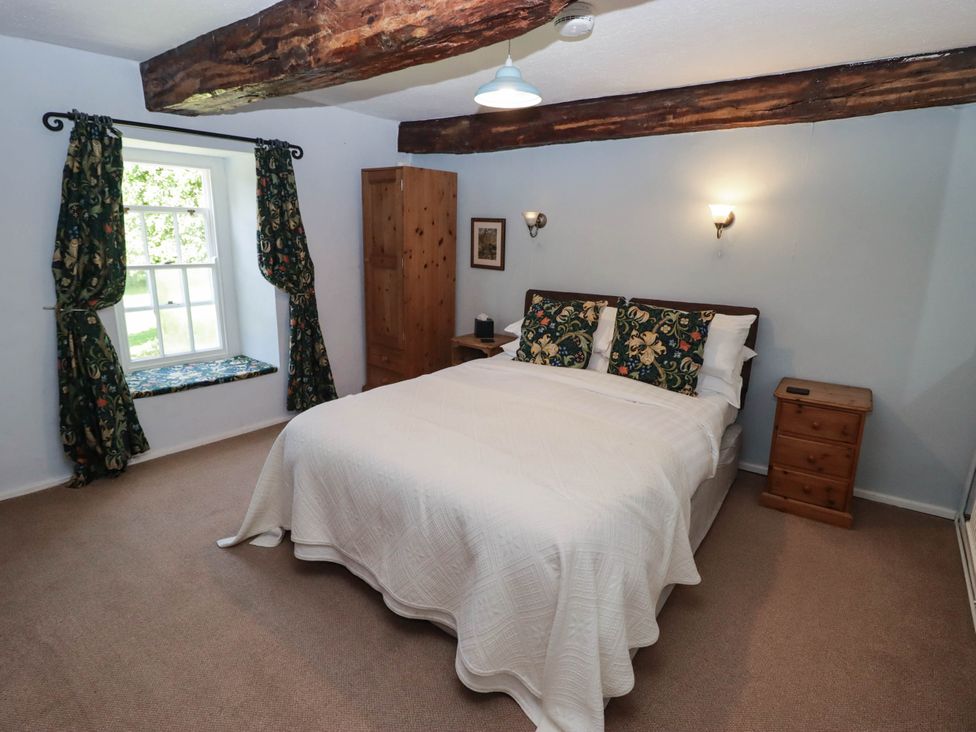 A bedroom with a bed and window at Ty Mawr Country House in Carmarthen