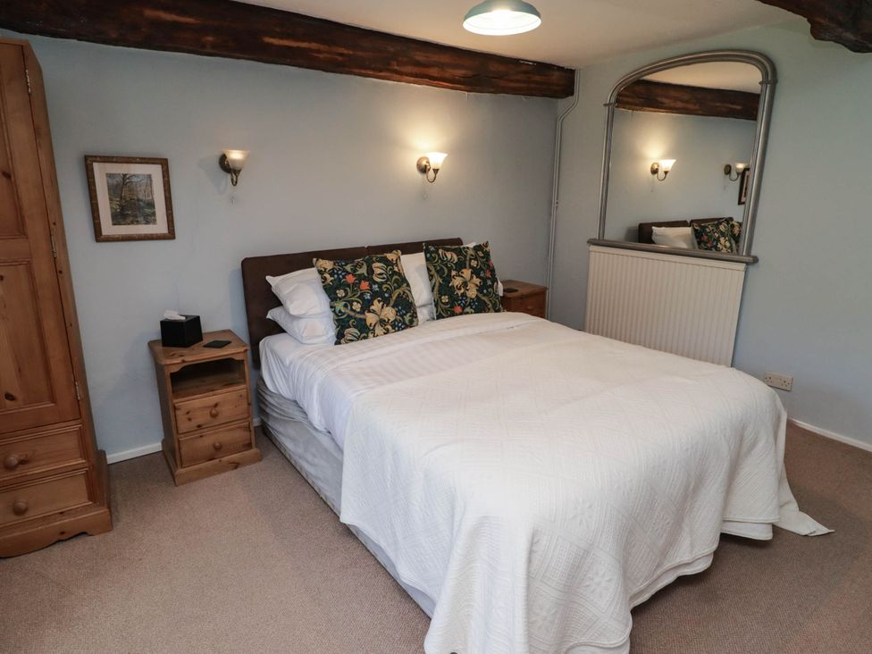 A bedroom with a bed and wardrobe at Ty Mawr Country House in Carmarthen