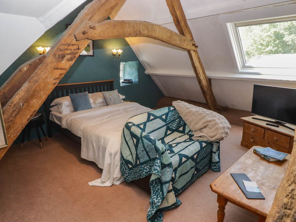 A bedroom with a bed and sofa at Ty Mawr Country House in Carmarthen
