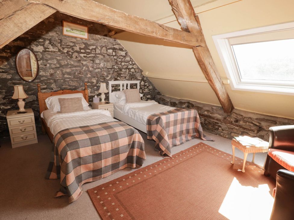 A bedroom with two single beds and a rug at Ty Mawr Country House in Carmarthen
