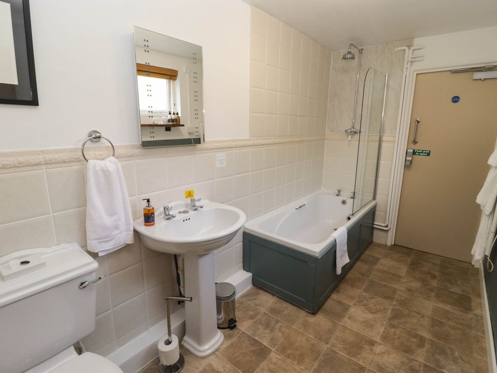 A bathroom with a sink, toilet, bath tub, and shower at Ty Mawr Country House in Carmarthen
