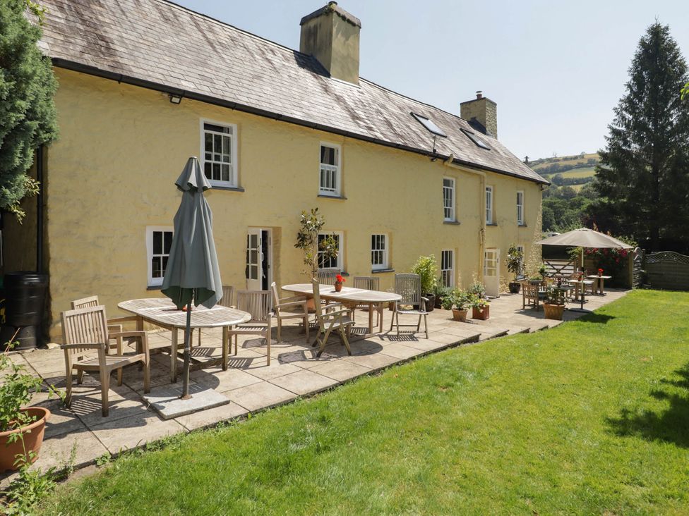 A house with patio furniture and garden at Ty Mawr Country House in Carmarthen