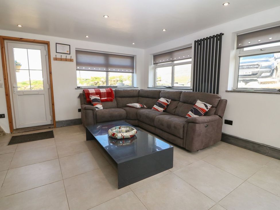 A living room with a sofa and coffee table at Cefnbron in Caernarfon