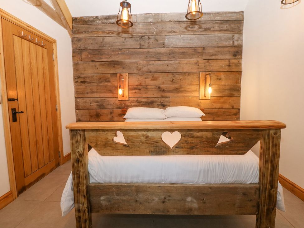 A bedroom with a wooden bed and wooden wall at Cefnbron in Caernarfon