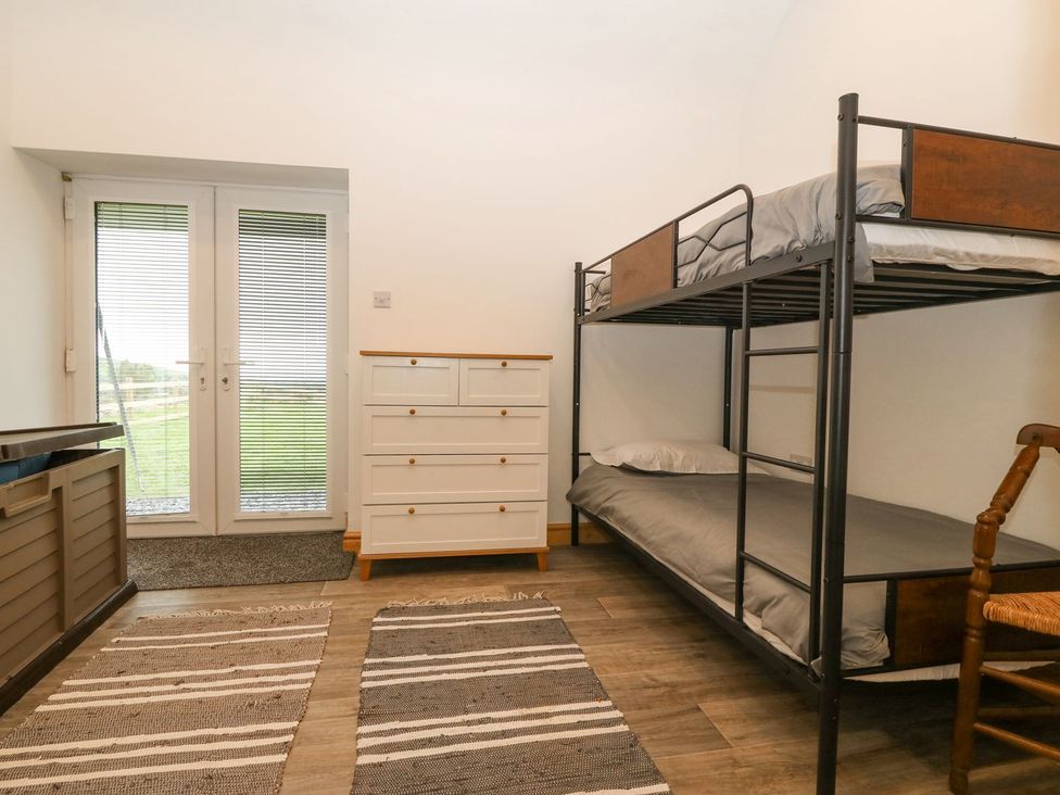 A bedroom with a bunk bed and dresser at Cefnbron in Caernarfon