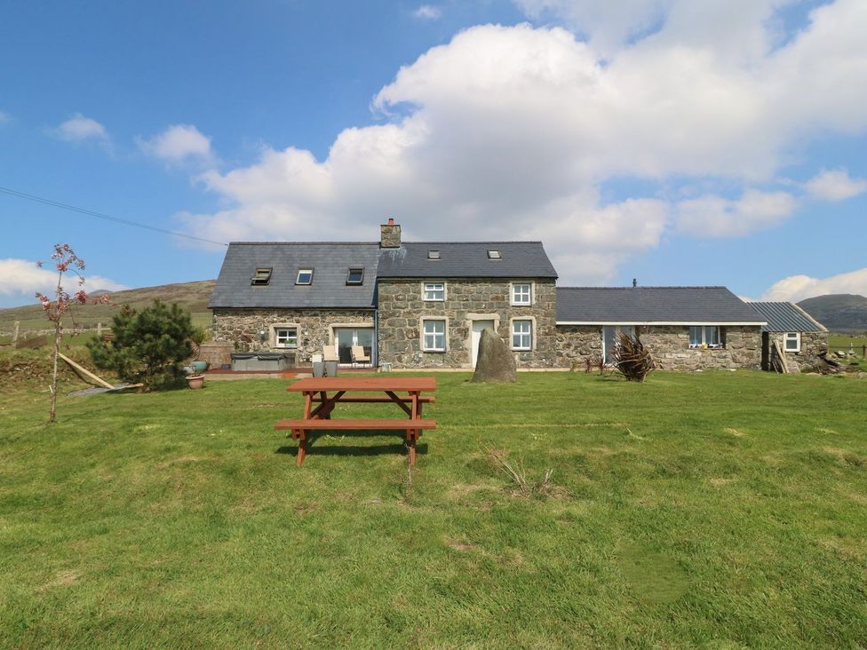 A house with a picnic table in the outdoor area at Cefnbron Caernarfon