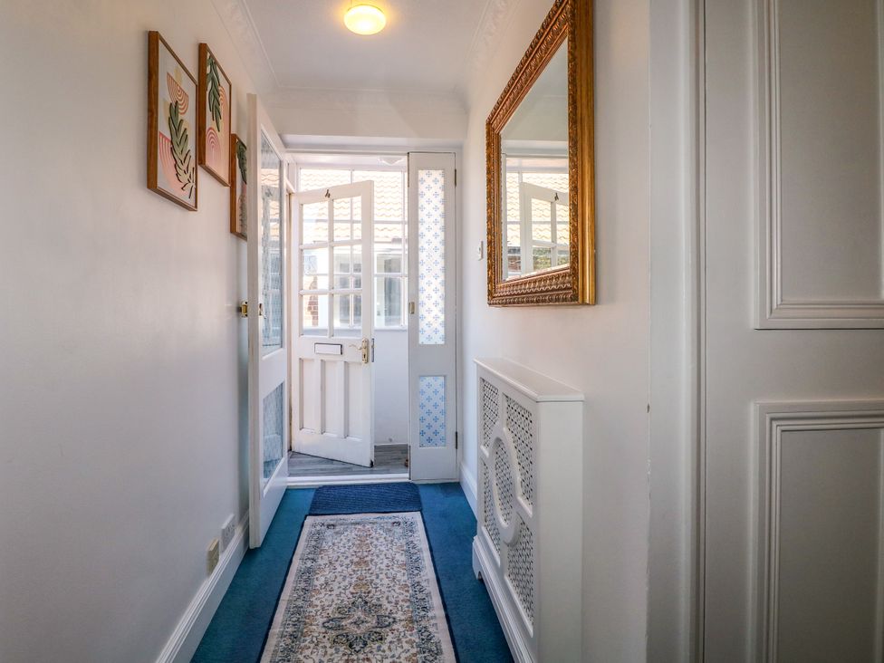A hallway with a door and a mirror at 4 Sussex Close, Watford