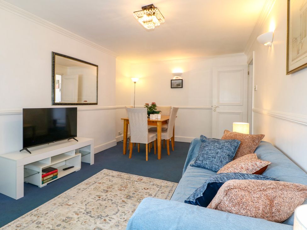 A living room with a television and a dining area at 4 Sussex Close Watford