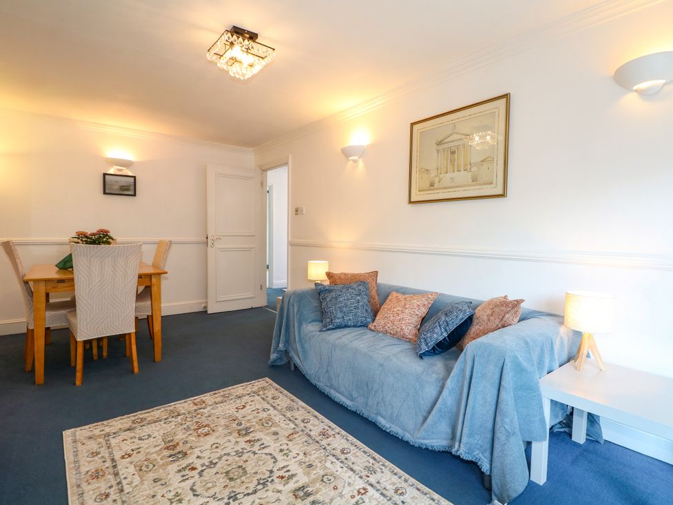 A living room with a sofa and dining table at 4 Sussex Close in Watford