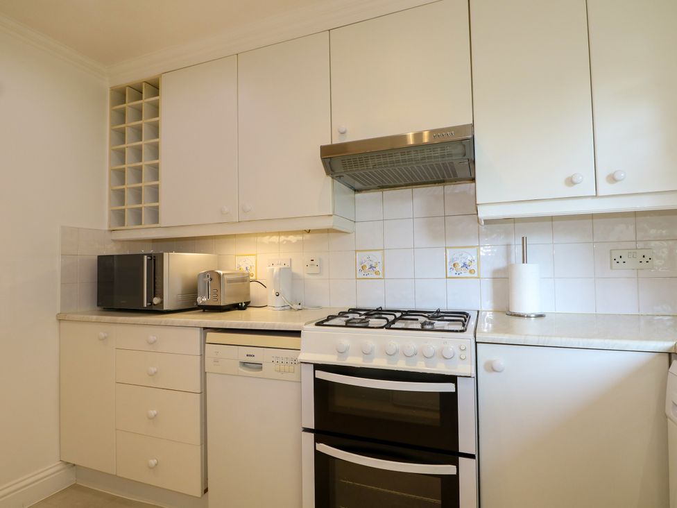 A kitchen with cabinets, appliances, and a countertop at 4 Sussex Close in Watford