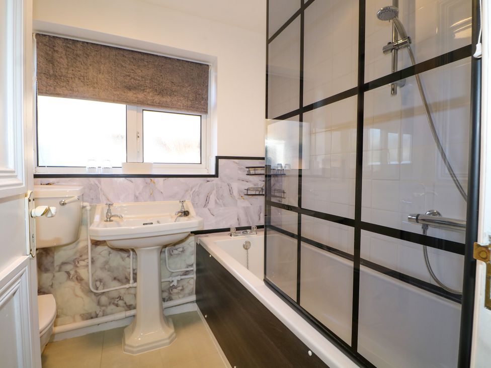 A bathroom with a sink, bathtub, and shower at 4 Sussex Close in Watford