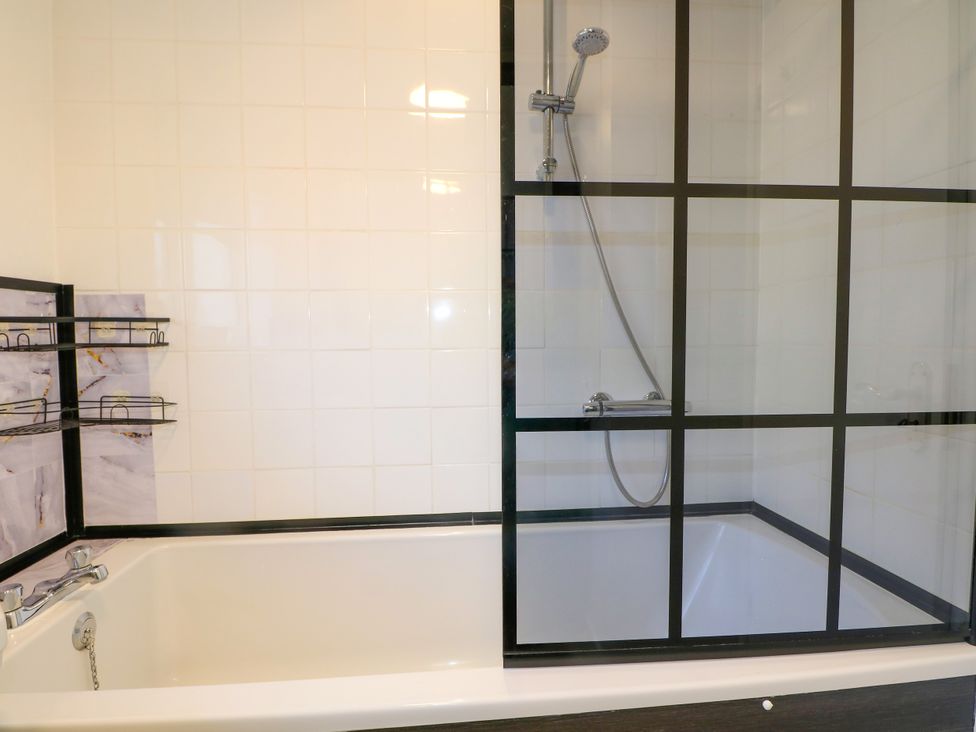 A bathtub and shower in a bathroom at 4 Sussex Close Watford