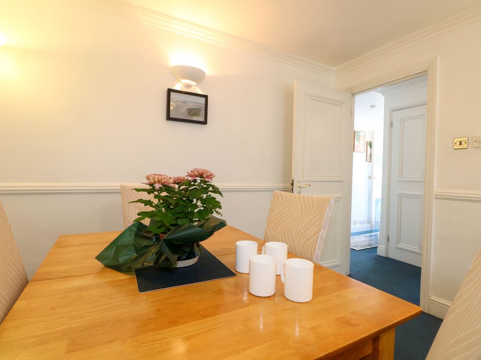 A dining room with a table and chairs at Sussex Close in New Malden