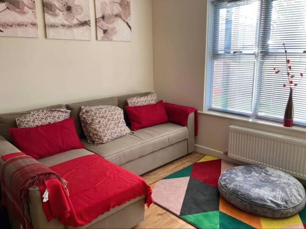 A living room with a sofa and cushions at Admirals Rest in Weymouth