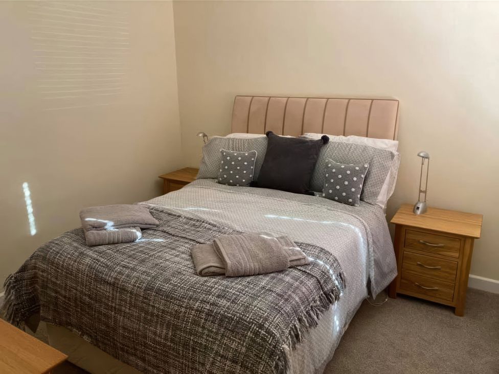 A bedroom with a bed and bedside tables at Admirals Rest in Weymouth