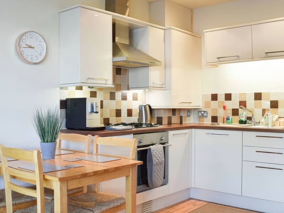 A kitchen with a table and chairs at Admirals Rest in Weymouth
