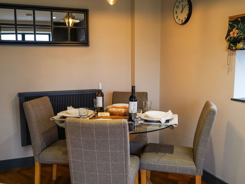 A dining room with a glass table and wine at The Old Mill in Great Bolas near Telford