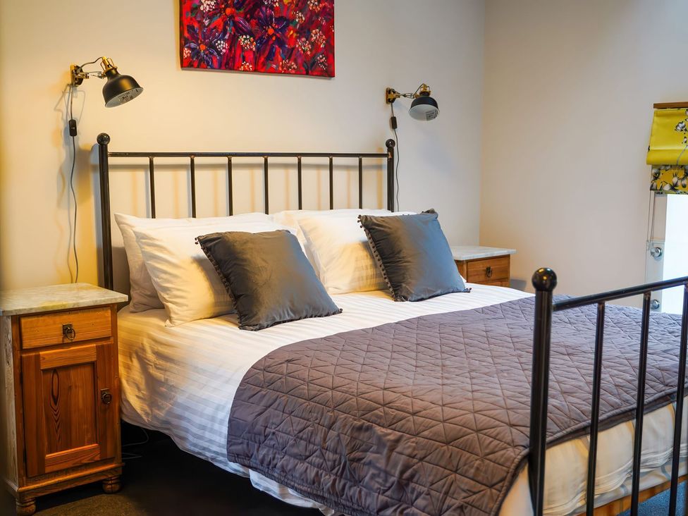 A bedroom with a bed and nightstands at The Old Mill in Great Bolas near Telford