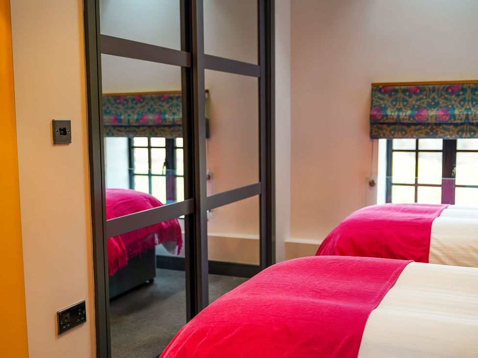 A bedroom with beds and a mirror at The Old Mill in Great Bolas near Telford
