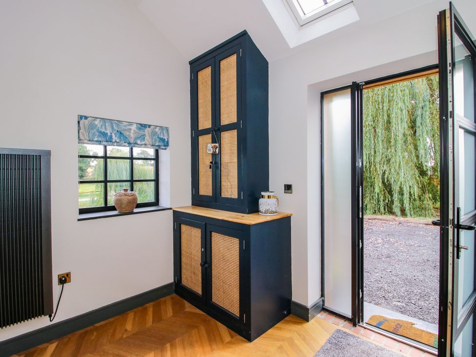 An entrance hall with a cabinet and window at The Old Mill near Great Bolas