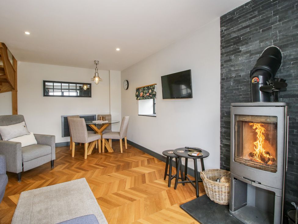 A living room with a fireplace and dining area at The Old Mill in Great Bolas near Telford