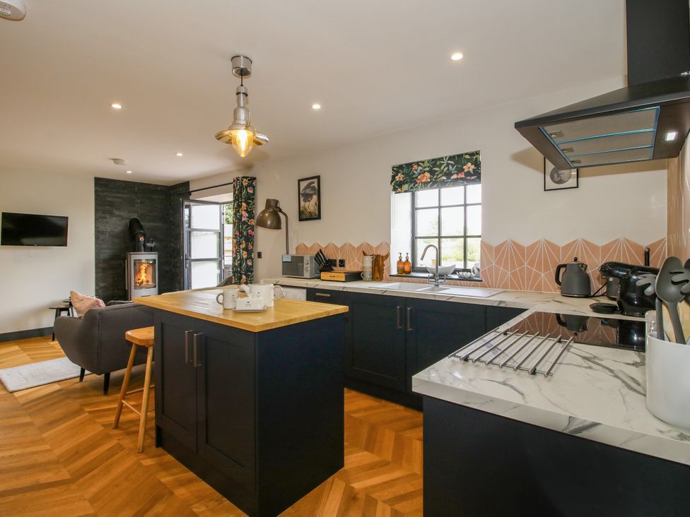 A kitchen with a fireplace and window at The Old Mill in Great Bolas near Telford