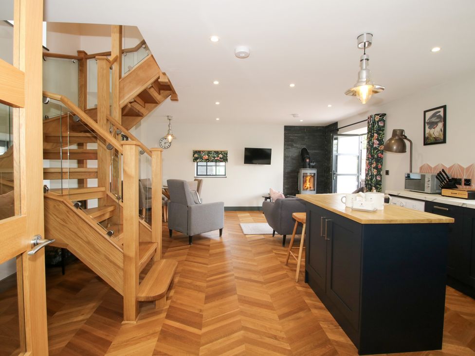 A living room with a staircase and kitchen area at The Old Mill Great Bolas near Telford