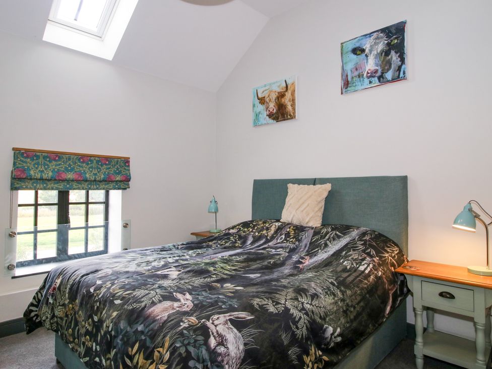 A bedroom with a bed and paintings at The Old Mill in Great Bolas near Telford