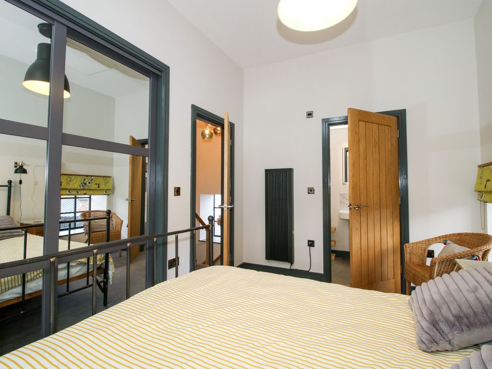 A bedroom with a bed, window, and door at The Old Mill in Great Bolas near Telford