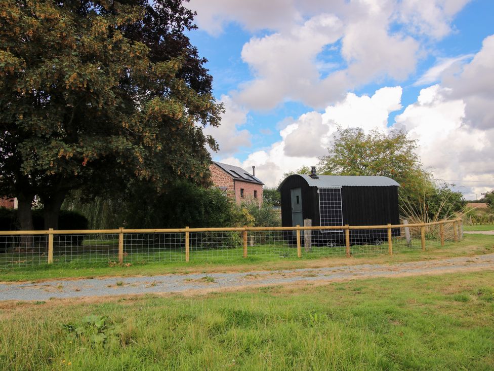 A shed and building under a tree in an outdoor area at The Old Mill in Great Bolas near Telford