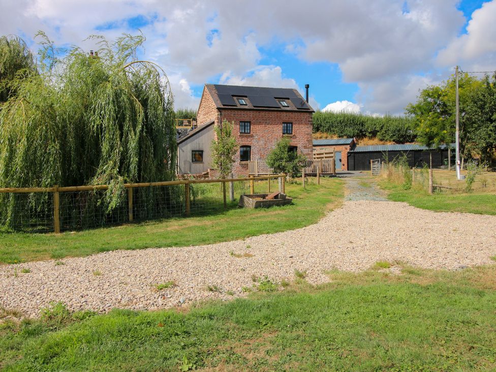 A house with a gravel path and trees at The Old Mill Great Bolas near Telford