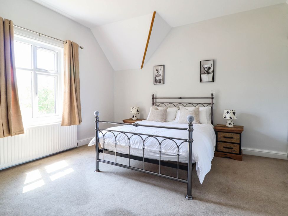 A bedroom with a bed and nightstand at Pwll Glas, Caersws