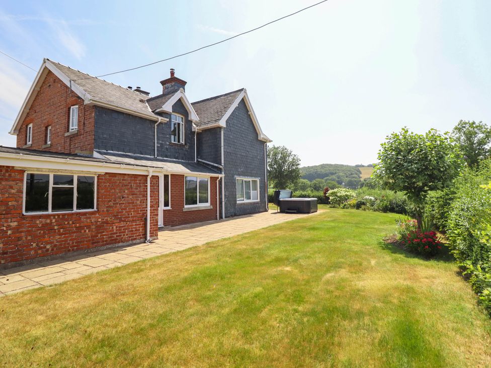 An outdoor area with a house and garden at Pwll Glas in Caersws