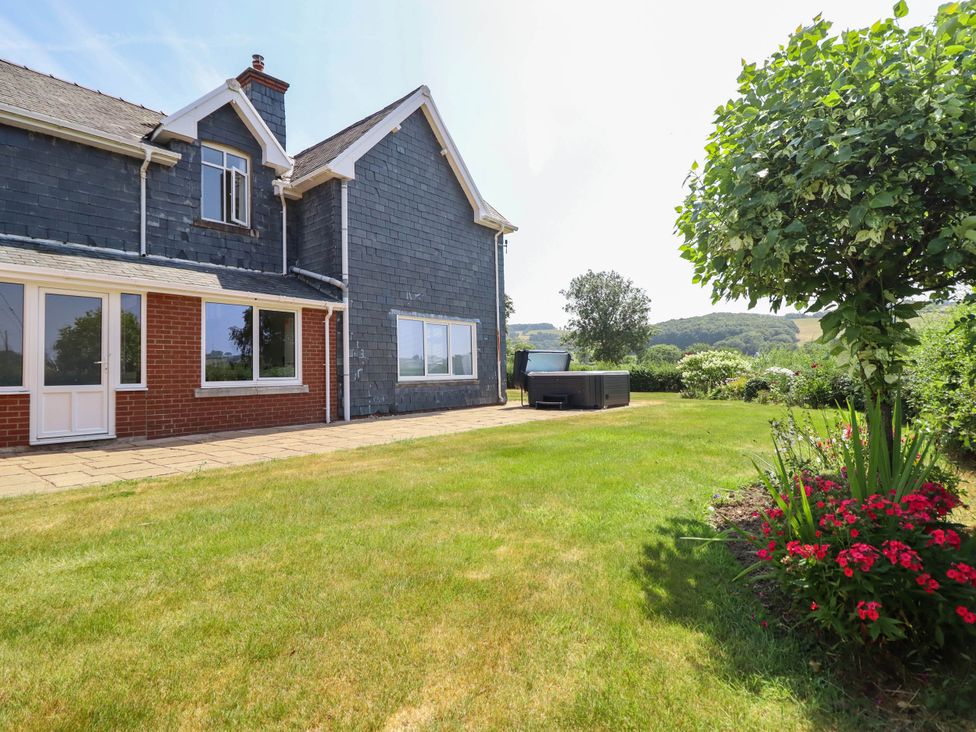 A house exterior with a patio and garden at Pwll Glas in Caersws