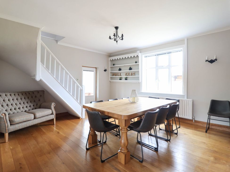 A dining room with a table and chairs at Pwll Glas in Trefeglwys