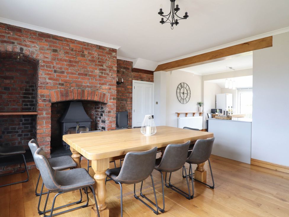 A dining room with a table and chairs at Pwll Glas in Trefeglwys