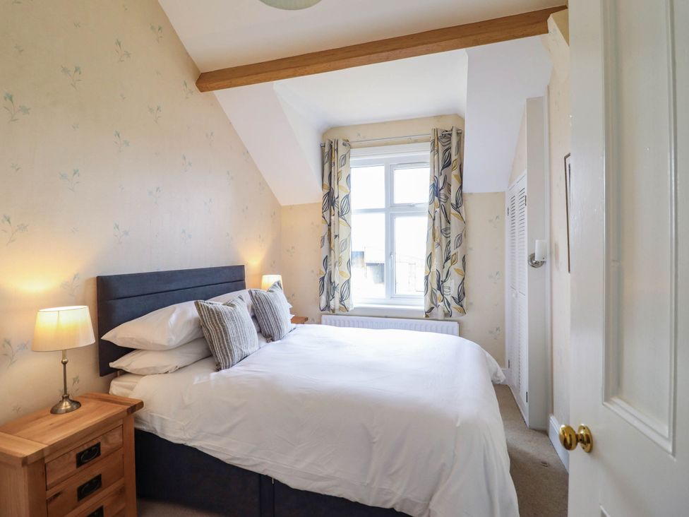A bedroom with a bed and window at Pwll Glas in Trefeglwys