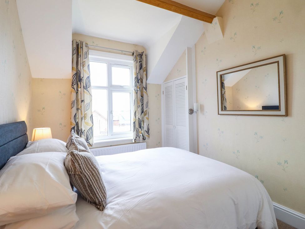 A bedroom with a bed and window at Pwll Glas in Trefeglwys
