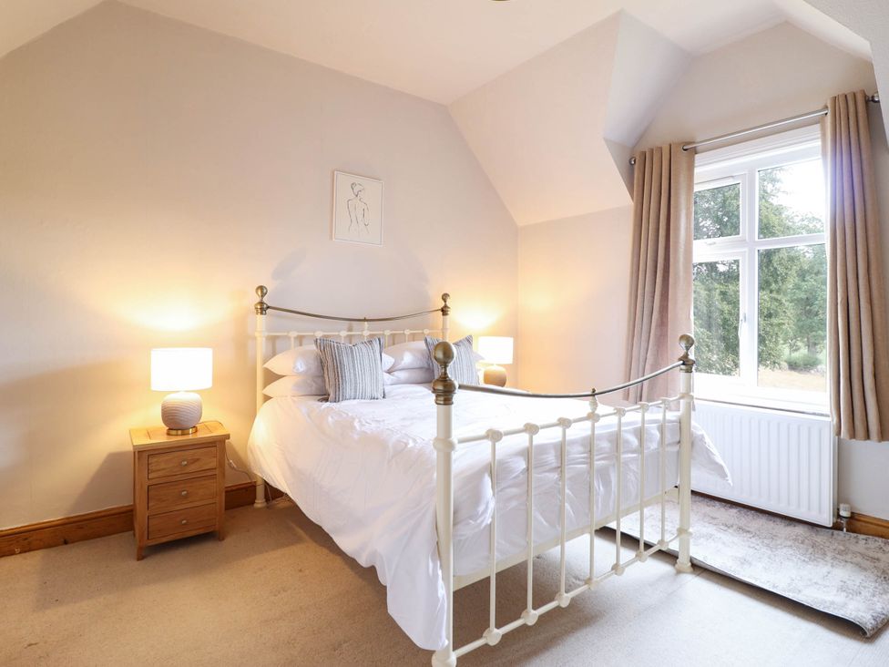 A bedroom with a bed and nightstand at Pwll Glas in Trefeglwys