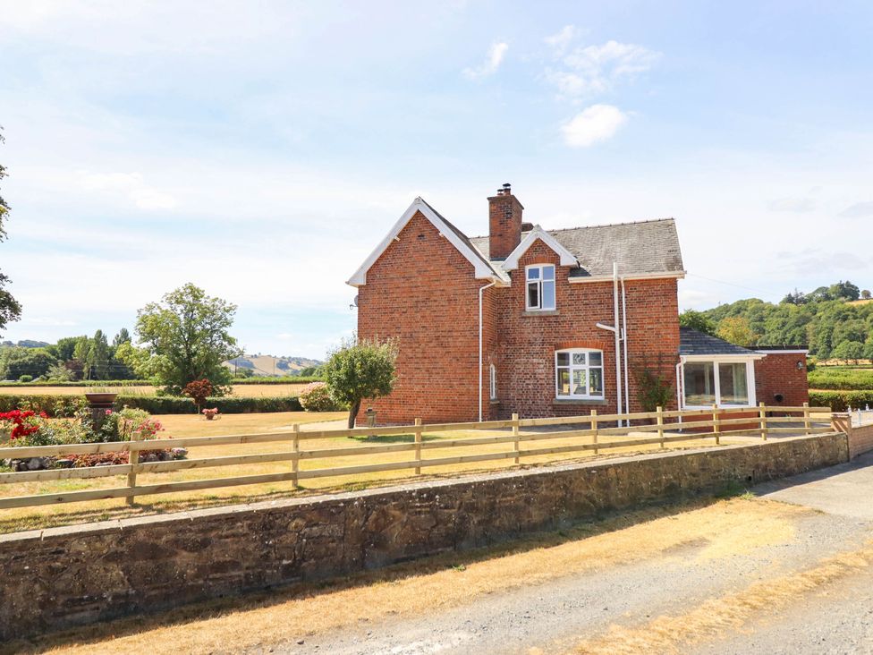 A house with a garden and a fence at Pwll Glas in Trefeglwys