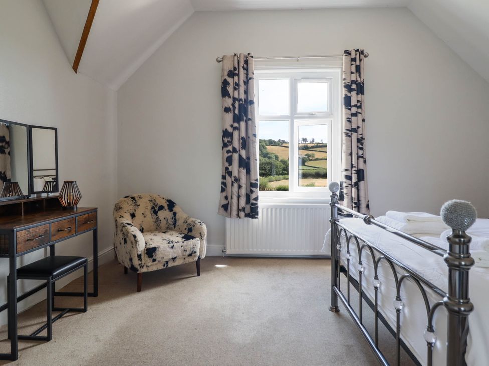 A bedroom with a bed and a dresser at Pwll Glas, Trefeglwys