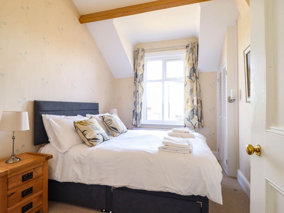 A bedroom with a double bed and window at Pwll Glas in Trefeglwys