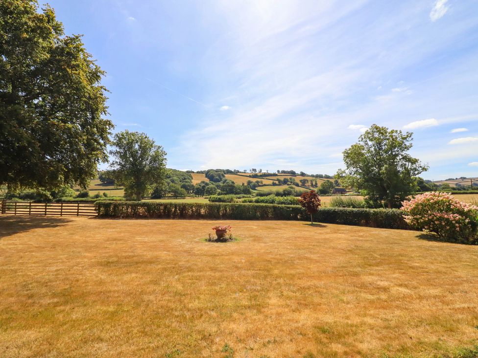 A garden with grass and trees at Pwll Glas in Trefeglwys