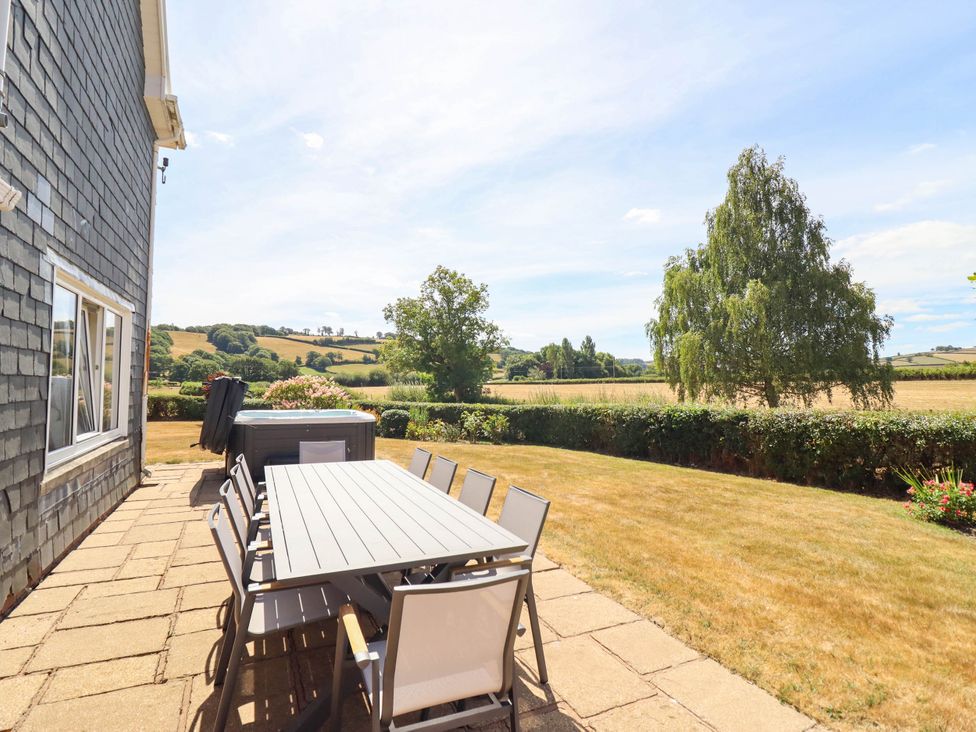 A garden with a table and chairs outside at Pwll Glas in Trefeglwys