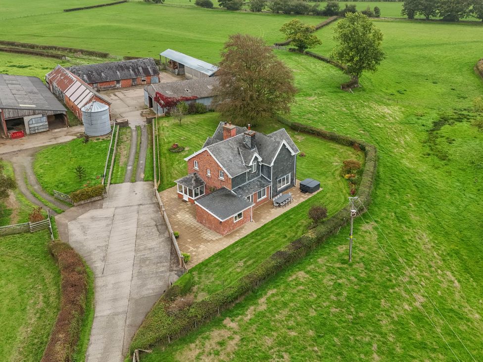 An aerial view of a house and farm buildings at Pwll Glas in Trefeglwys