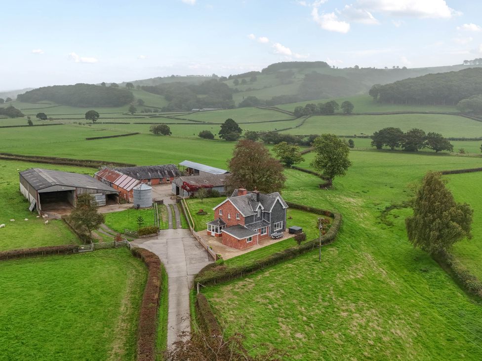 An aerial view of a house and farm in a rural area at Pwll Glas, Trefeglwys